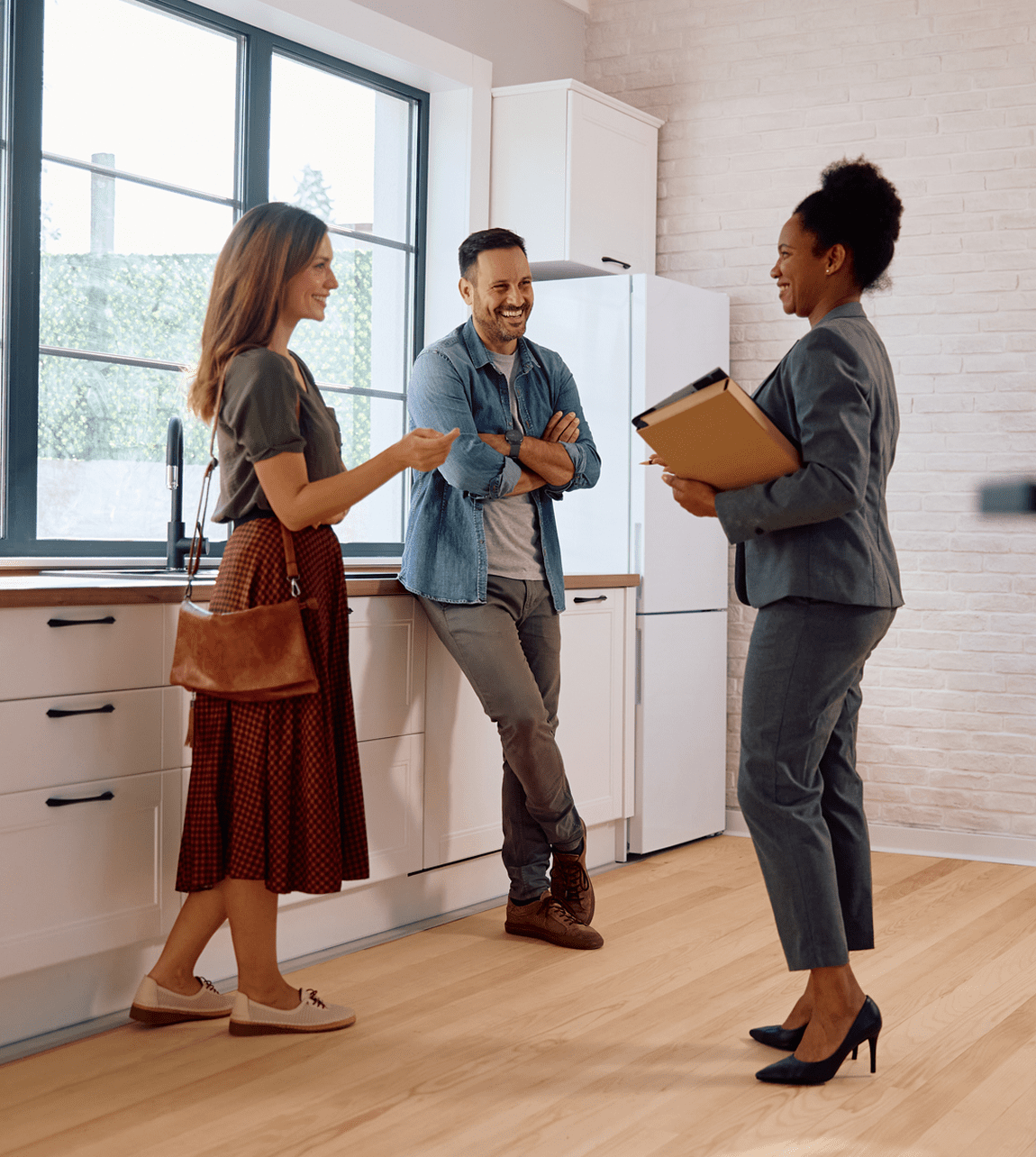 Three people talking in a kitchen.